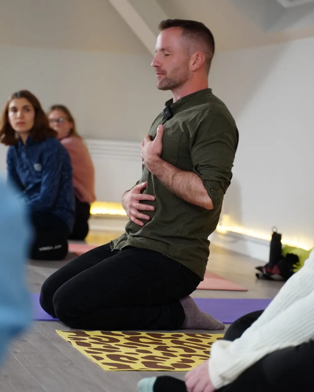 Pat teaching, one hand on his chest and one on his belly