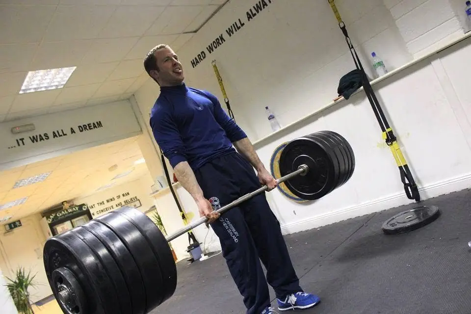 Pat deadlifting a heavily loaded barbell in his gym