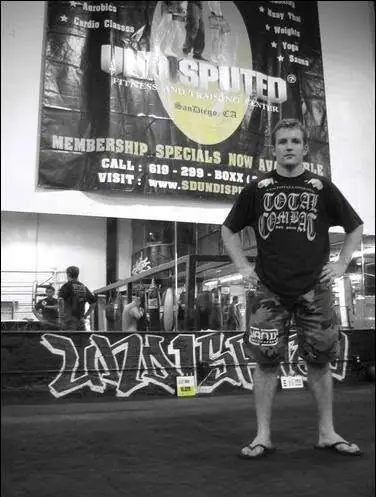 Black and white photo of a 19-year-old Pat standing in an MMA gym in San Diego